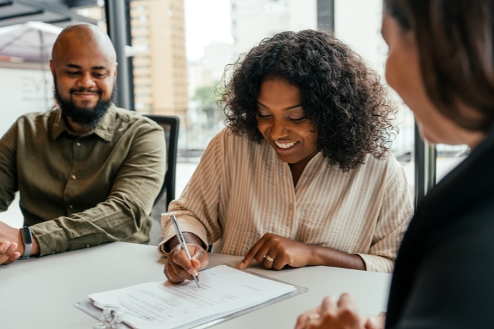 couple signing contract with advisor@2x