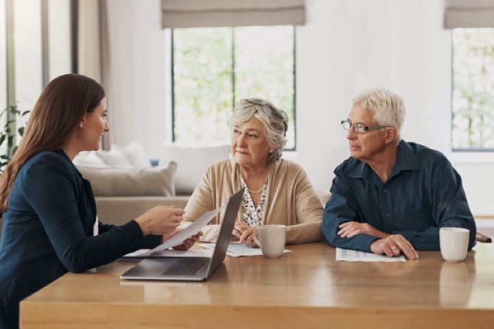 elderly couple talks with financial advisor@2x
